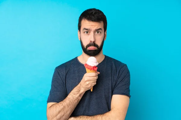 Junger Mann Mit Einem Kornett Eis Vor Isoliertem Blauen Hintergrund — Stockfoto