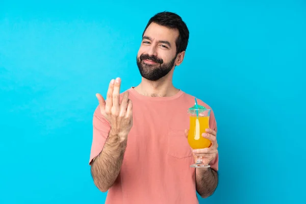 Junger Mann Hält Einen Cocktail Vor Isoliertem Blauen Hintergrund Und — Stockfoto