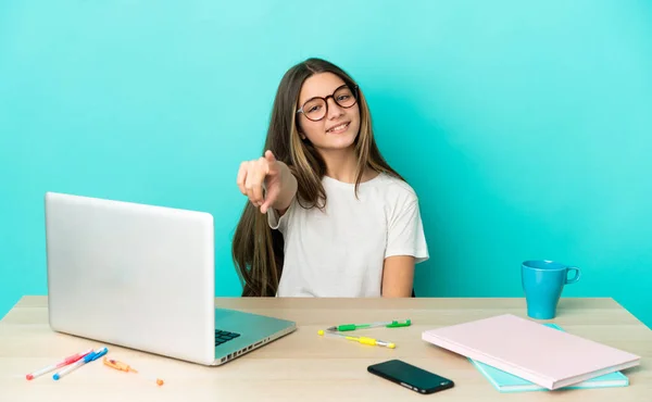 Menina Uma Mesa Com Laptop Sobre Fundo Azul Isolado Apontando — Fotografia de Stock