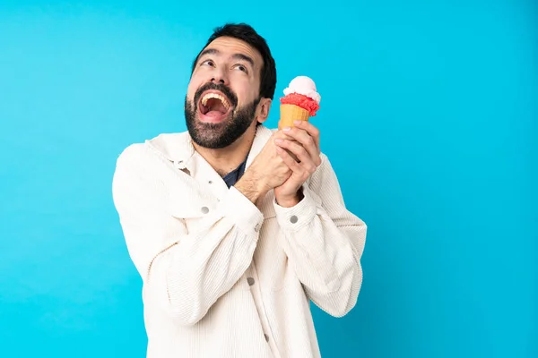 Junger Mann Mit Einem Kornetteis Vor Isoliertem Blauen Hintergrund — Stockfoto