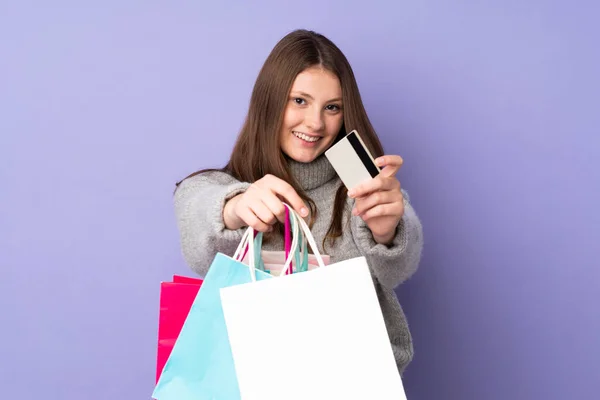 Tiener Kaukasisch Meisje Geïsoleerd Paarse Achtergrond Holding Boodschappentassen Een Creditcard — Stockfoto