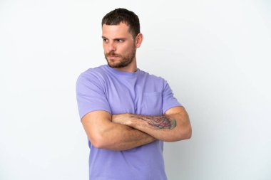 Beyaz arka planda izole edilmiş genç Brezilyalı adam kollarını çapraz tutuyor.