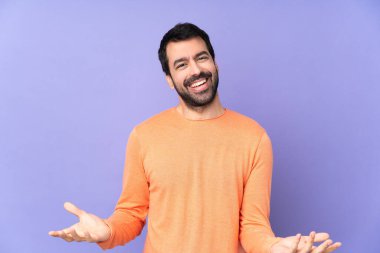 İzole edilmiş mor arka planda gülümseyen beyaz yakışıklı bir adam.