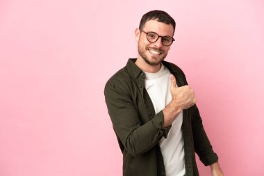 Genç Brezilyalı bir adam pembe arka planda soyutlanmış gururlu ve kendinden memnun