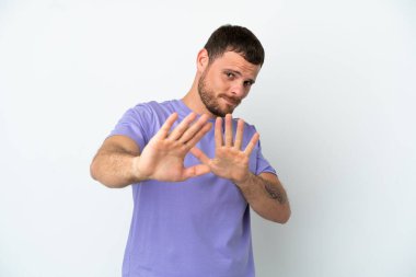 Beyaz arka planda izole edilmiş genç Brezilyalı adam sinirleri öne doğru geriliyor.