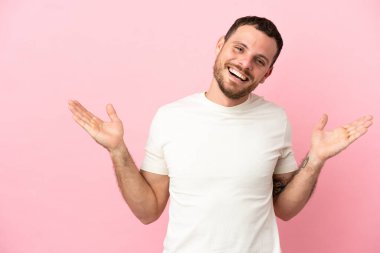 Pembe arka planda yüzü şoke olmuş genç Brezilyalı bir adam.