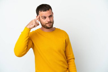 Genç Brezilyalı adam beyaz arka planda soyutlanmış. Delilik jesti yapıyor. Parmağını kafaya koyuyor.