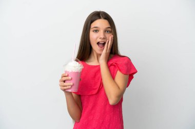 Çilekli milkshake ile izole edilmiş beyaz arka planda şaşırmış ve şok olmuş bir yüz ifadesi olan küçük kız.
