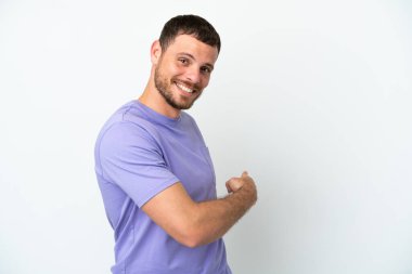 Beyaz arka planda izole edilmiş genç Brezilyalı adam geriye doğru işaret ediyor