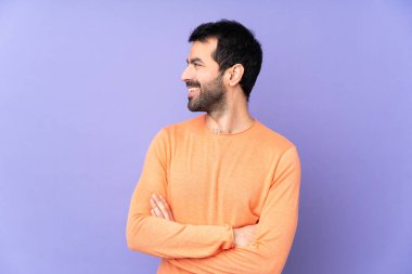 İzole edilmiş mor arka planda beyaz, yakışıklı bir adam.