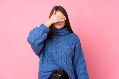 Genç beyaz kız pembe arka planda izole edilmiş gözlerini elleriyle kapatıyor. Bir şey görmek istemiyorum.