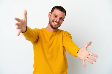 Beyaz arka planda izole edilmiş genç Brezilyalı adam sunar ve davet eder.