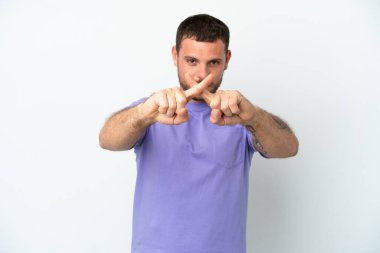 Genç Brezilyalı bir adam beyaz arka planda izole edilmiş bir şekilde bir eylemi durdurmak için el hareketi yapıyor.