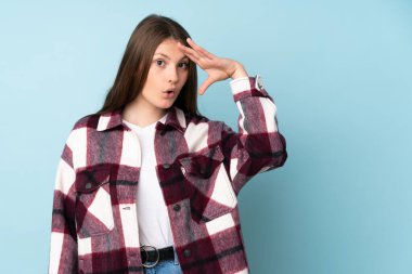 Mavi arka planda izole genç beyaz kız bir şey fark etti ve çözüme niyetlendi.