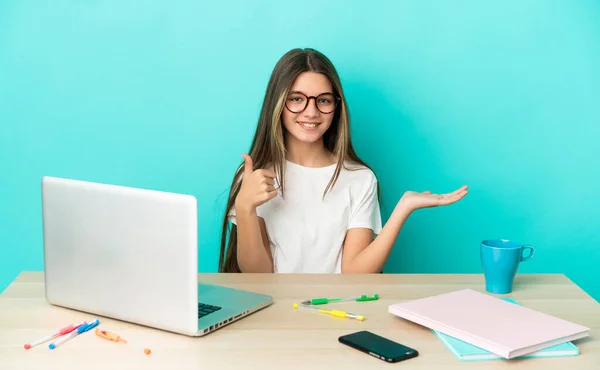 Menina Uma Mesa Com Laptop Sobre Fundo Azul Isolado Segurando — Fotografia de Stock