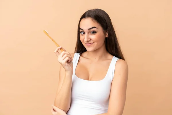 Jonge Kaukasische Vrouw Geïsoleerd Beige Achtergrond Met Een Tandenborstel — Stockfoto