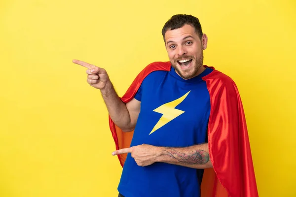 Super Hrdina Brazilský Muž Izolovaný Žlutém Pozadí Překvapen Ukazuje Stranou — Stock fotografie