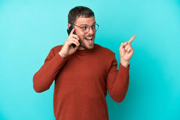 Mladý Brazilec Používající Mobilní Telefon Izolovaný Modrém Pozadí Úmyslem Realizovat — Stock fotografie