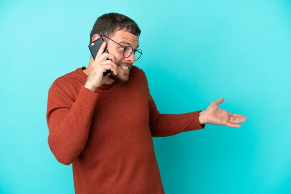 Mladý Brazilský Muž Pomocí Mobilního Telefonu Izolované Modrém Pozadí Překvapivým — Stock fotografie
