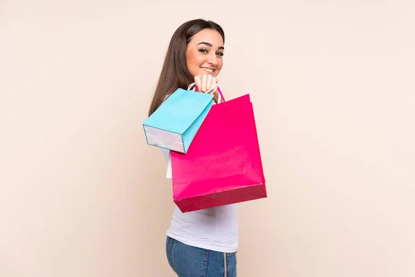 Young Caucasian Woman Isolated Beige Background Holding Shopping Bags Smiling — Stock Photo, Image