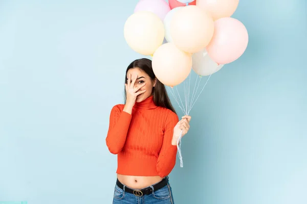 Junge Frau Fängt Viele Luftballons Isoliert Auf Blauem Hintergrund Die — Stockfoto
