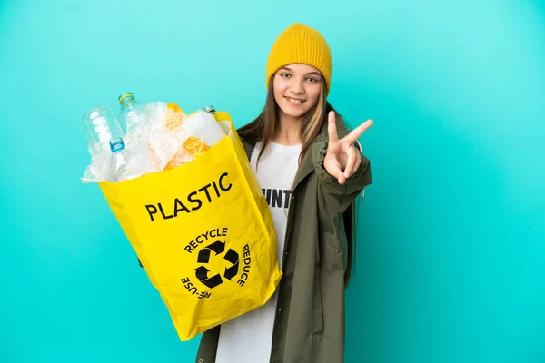 Mała Dziewczynka Trzyma Torbę Pełną Plastikowych Butelek Recyklingu Odizolowanym Niebieskim — Zdjęcie stockowe