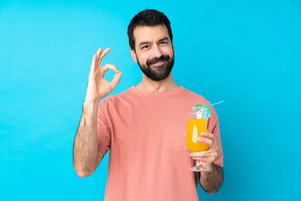 Junger Mann Hält Einen Cocktail Über Einen Isolierten Blauen Hintergrund — Stockfoto