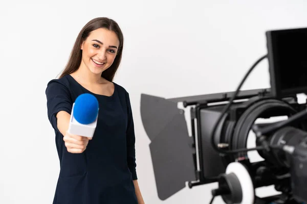 Reporter woman holding a microphone and reporting news isolated on white background