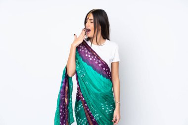 Genç Hintli bir kadın beyaz arka planda izole edilmiş esniyor ve ağzını eliyle açık tutuyor.