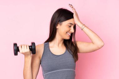 Pembe arka planda halter yapan genç kadın bir şey fark etti ve çözüme niyetlendi.