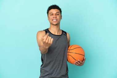 Basketbolcu Afrikalı Amerikalı adam mavi arka planda izole edildi.