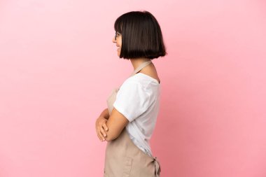 Soyutlanmış pembe arka planda restoran garsonu yan pozisyonda.