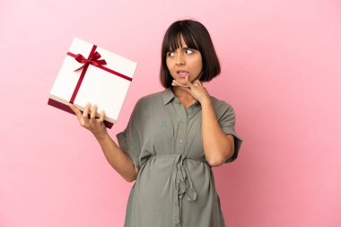 Tecrit edilmiş bir kadın hamile ve elinde şüpheleri olan bir hediye tutuyor.