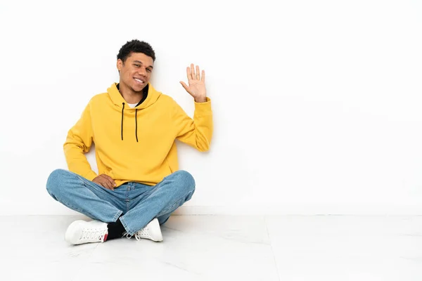 Young African American Man Sitting Floor Isolated White Background Saluting — Stock Photo, Image