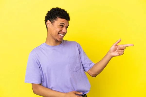 Jonge Afro Amerikaanse Man Geïsoleerd Gele Achtergrond Wijzend Vinger Naar — Stockfoto