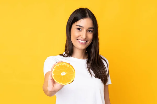 Ung Kaukasiska Kvinna Som Håller Orange Isolerad Gul Bakgrund Med — Stockfoto