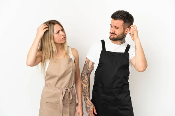 Restaurant waiter over isolated white background having doubts while scratching head