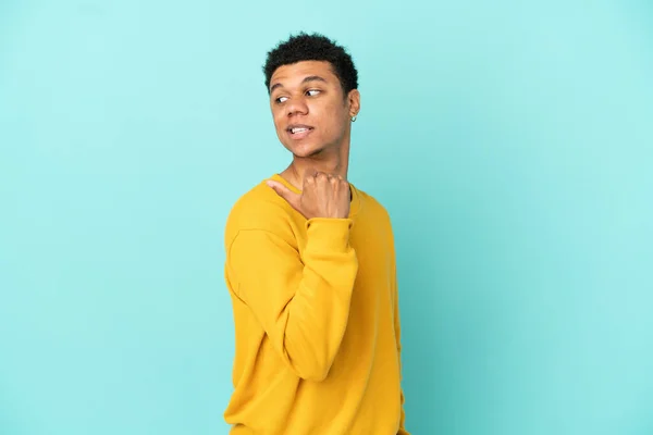 Joven Hombre Afroamericano Aislado Sobre Fondo Azul Apuntando Hacia Lado — Foto de Stock