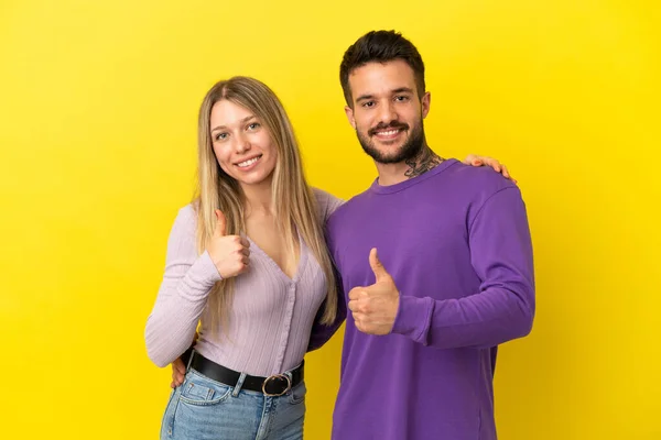 Pareja Joven Sobre Fondo Amarillo Aislado Dando Pulgares Hacia Arriba —  Fotos de Stock