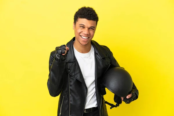 年轻的非洲裔美国人头戴摩托车头盔 被黄色背景隔离 庆祝胜利 — 图库照片