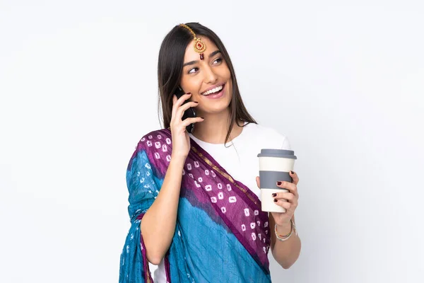 Młoda Hinduska Kobieta Odizolowana Białym Tle Trzymając Kawę Zabrania Telefon — Zdjęcie stockowe