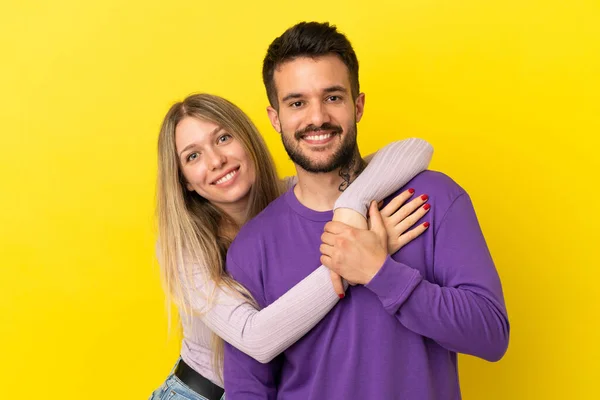 Casal Jovem Sobre Isolado Fundo Amarelo Rindo Abraçando — Fotografia de Stock