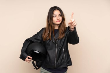 Motosiklet kasklı kadın bej arka planda izole edilmiş şeffaf ekrana dokunuyor.