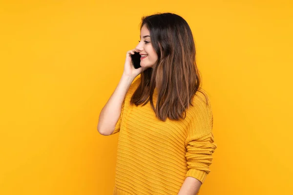Молода Біла Жінка Ізольована Жовтому Тлі Тримаючи Розмову Мобільним Телефоном — стокове фото