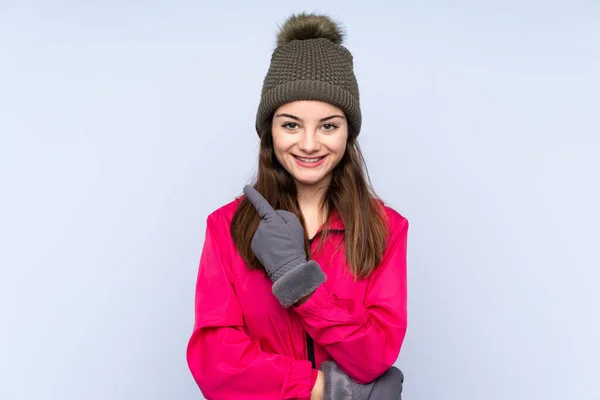 Νεαρό Κορίτσι Χειμερινό Καπέλο Απομονωμένο Μπλε Φόντο Που Δείχνει Προς — Φωτογραφία Αρχείου