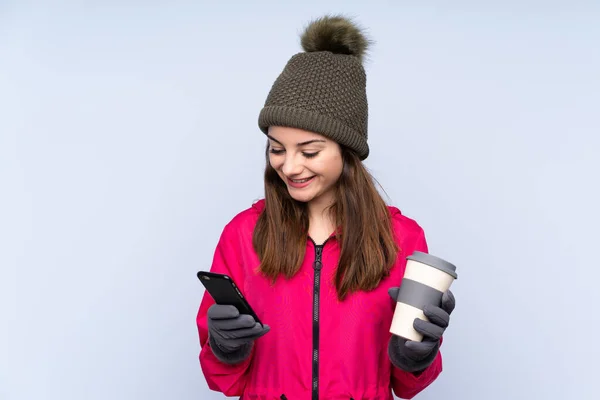 Menina Com Chapéu Inverno Isolado Fundo Azul Segurando Café Para — Fotografia de Stock