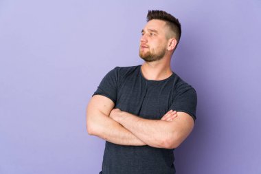 Soyutlanmış bir geçmişi olan yakışıklı Rus bir adam yan tarafa bakıyor.