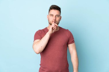 Tecrit edilmiş Rus yakışıklı adam sessizlik işareti gösteriyor. Parmağını ağzına sokuyor.