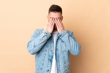 İzole edilmiş arka planda, gözleri elleriyle kaplayan Rus yakışıklı adam.