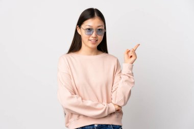 Genç Çinli kız izole edilmiş beyaz arka planda mutlu ve dik duruyor.